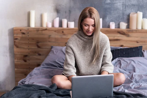 Красива жінка використовує ноутбук у своїй спальні — стокове фото