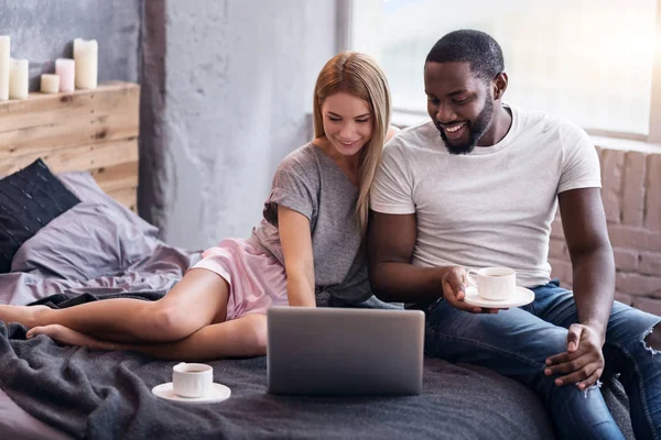 Dolce coppia sdraiata in camera da letto con laptop — Foto Stock