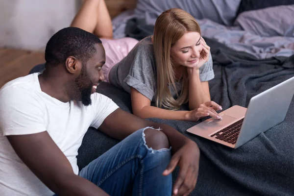 Internationella par använder laptop i sängen — Stockfoto
