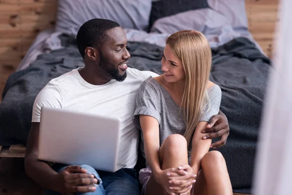 Vackra paret sitter i sovrummet med laptop — Stockfoto