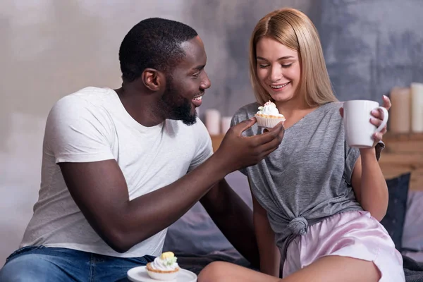 African American man feeding his girlfriend with cupcake — Stock Photo, Image
