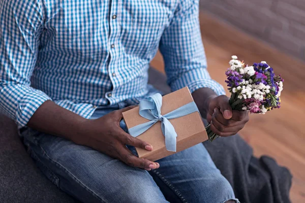 Close up van blij man met bloemen en cadeau — Stockfoto