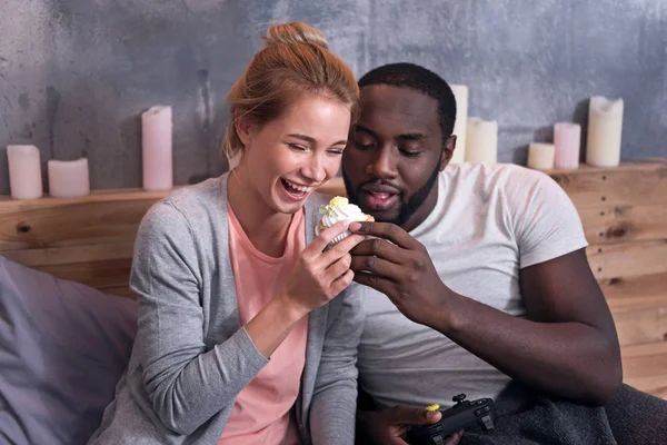 Coppia di giocatori mangiare cupcake in camera da letto — Foto Stock