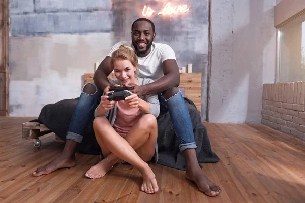 Encantada pareja jugando videojuegos en su dormitorio — Foto de Stock