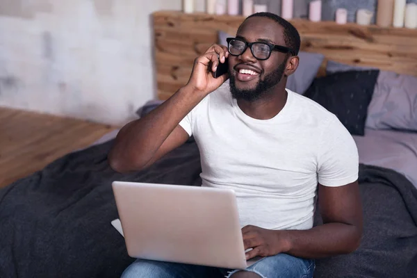 Afrikaner telefoniert im Schlafzimmer mit einem Handy — Stockfoto