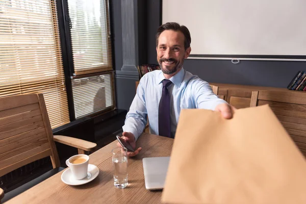 Good looking pleasant man giving you an envelope — Stock Photo, Image