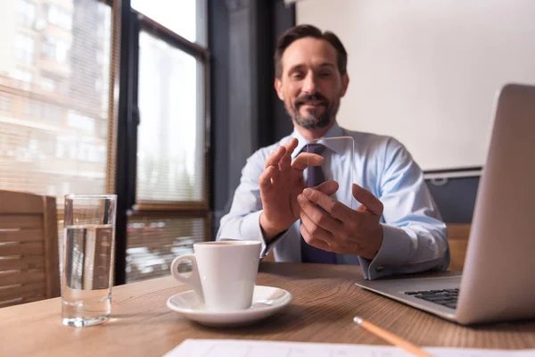 Handsome joyful man holding a cell phone — Stock Photo, Image