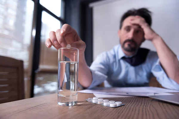 Cheerless depressed man taking medicine — Stock Photo, Image