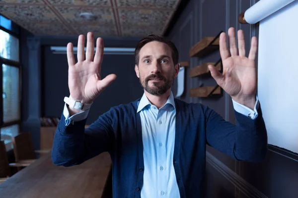 Очаровательный мужчина прижимает руки к виртуальной панели — стоковое фото