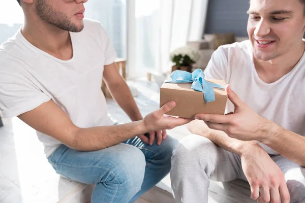 Man die een geschenk presenteert aan zijn vriendje. — Stockfoto