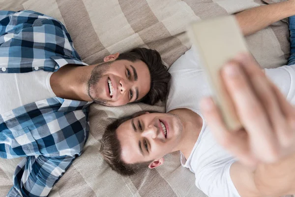 Yatakta selfie çeken eşcinsel çift. — Stok fotoğraf