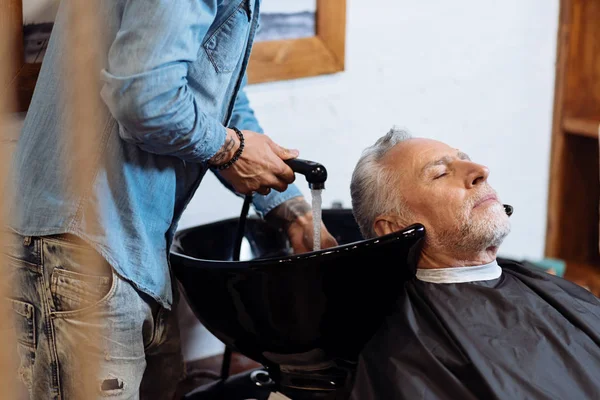 Senior man during washing hair in barbershop — Stock Photo, Image