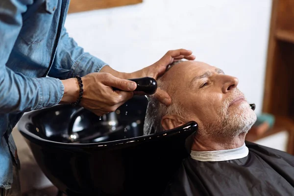 Gammel mand under vask hans hår i barber shop - Stock-foto