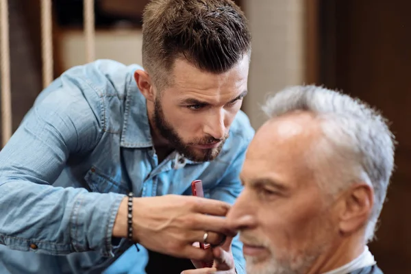 Крупним планом молодий чоловічий перукар, що ріже волосся — стокове фото