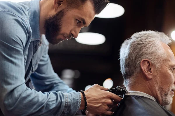 Hairdresser trimming neck of senior client — Stock Photo, Image