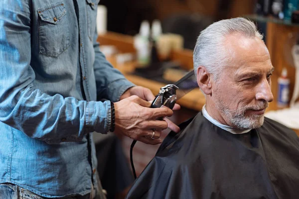Close up barber trimming hair of old man — Stock Photo, Image