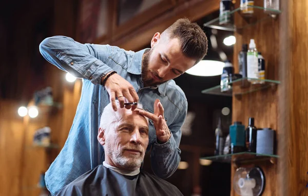 Barber cutting forehead hair with special knife — Stock Photo, Image