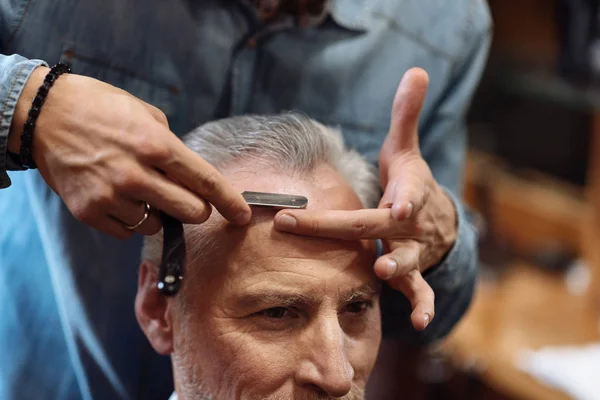 Крупный план пожилого человека, стригущегося в парикмахерской — стоковое фото