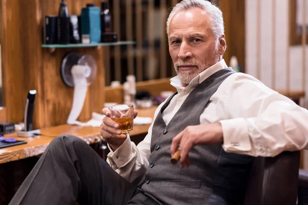 Man sitting with cognac glass and cigar