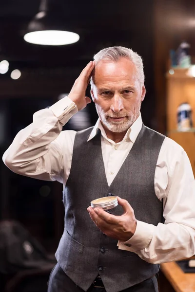 Senior-Geschäftsmann mit Haargel vor Spiegel — Stockfoto