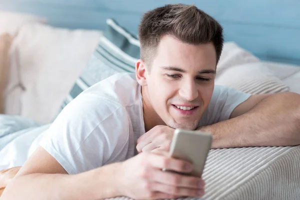 Щасливий молодий чоловік використовує мобільний телефон . — стокове фото