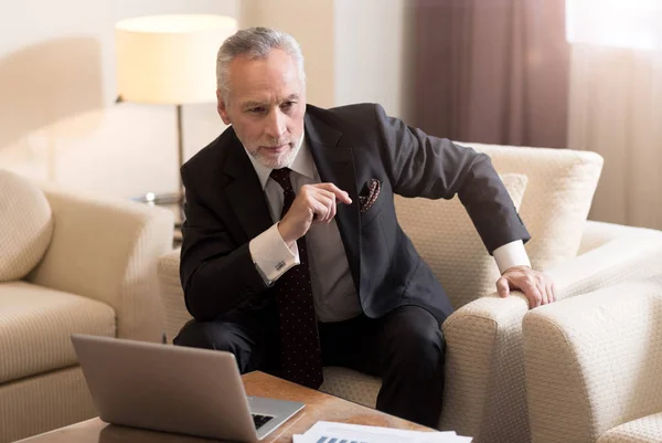 Encantado hombre de negocios sentado frente a la computadora portátil — Foto de Stock