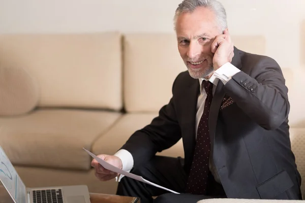 Agradable hombre de negocios barbudo hablando por teléfono en el hotel — Foto de Stock