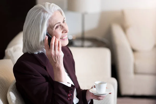 Boldog üzletasszony ivó kávé és beszél a telefonon — Stock Fotó