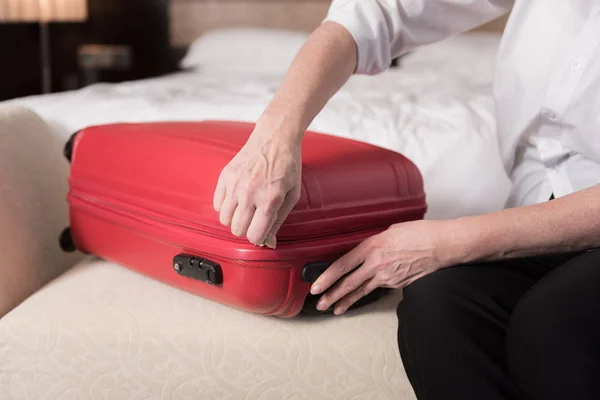 Червона сучасна валіза лежить на дивані — стокове фото