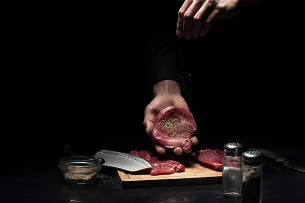 Close up of mans hands spicing the meat — Stock Photo, Image