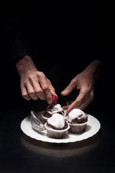 Primo piano di mani di uomo decorazione cupcake — Foto Stock