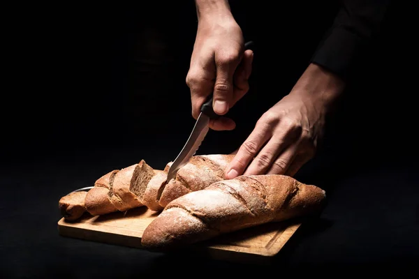 Tutup tangan laki-laki memotong baguette — Stok Foto