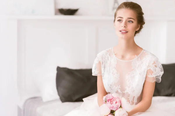 Young bride sitting on the bed at home — Stock Photo, Image