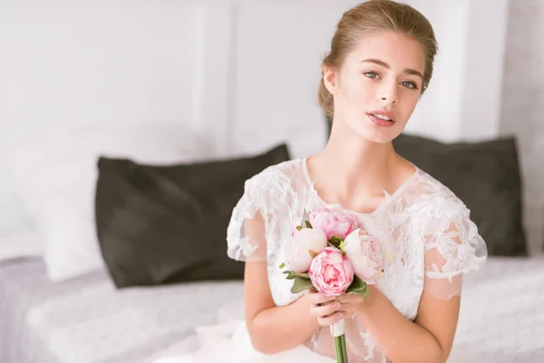 Affascinante giovane sposa che tiene il bouquet — Foto Stock