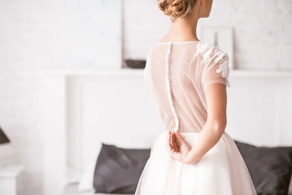 Young bride standing back and touching her dress — Stock Photo, Image