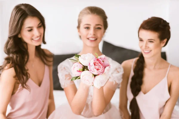 Exited bride sitting in the bedroom with her bridesmaids — Stock Photo, Image