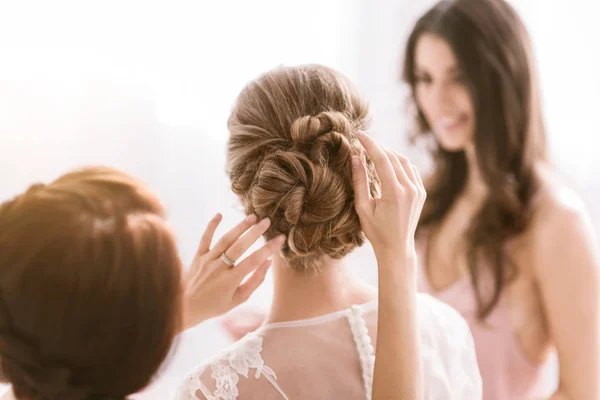 Pleasant bridesmaids helping the bride with her hairstyle — Stock Photo, Image
