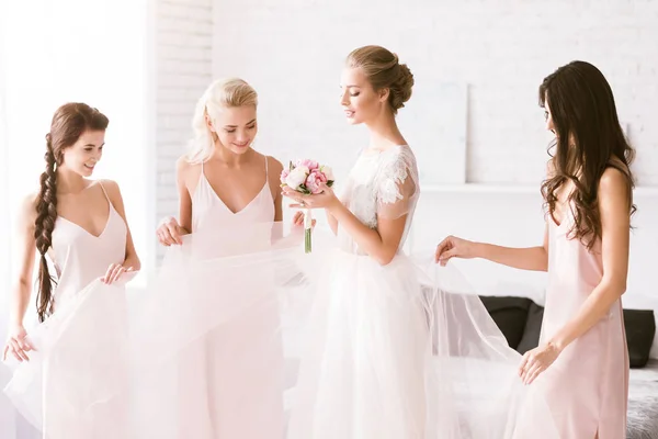 Damas de honor divertidas tocando el vestido de la novia — Foto de Stock