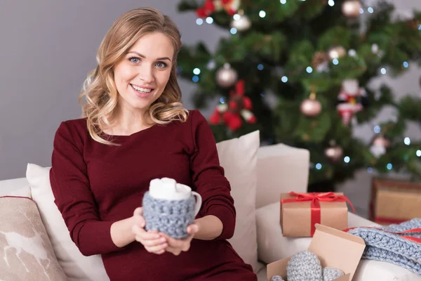 Fröhliche hübsche Frau bietet Ihnen eine Tasse Kakao an — Stockfoto