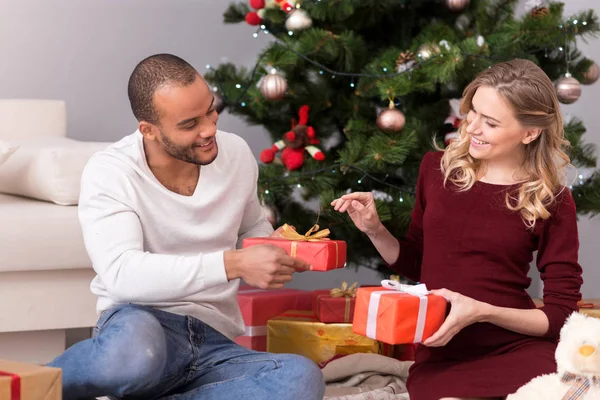 Positive delighted couple exchanging their presents — Stock Photo, Image