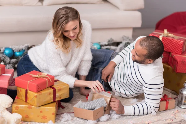 Pretty curious woman unpacking her presents — Stock Photo, Image