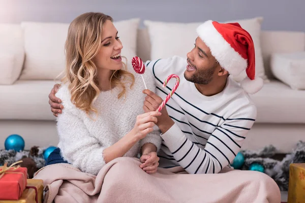 Positive joyful couple giving candies to each other — Stock Photo, Image