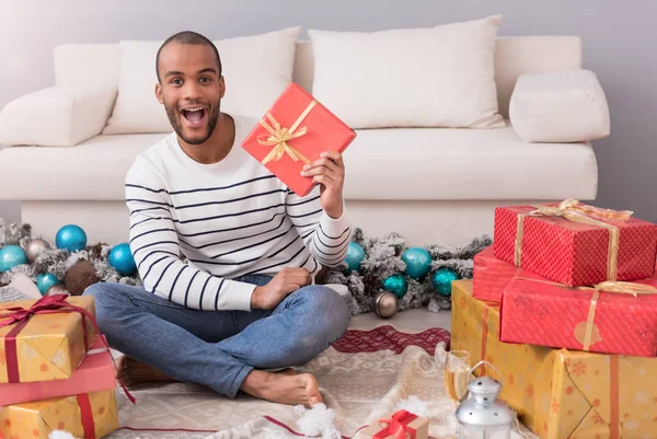 Glücklicher optimistischer Mann hält sein Geschenk — Stockfoto