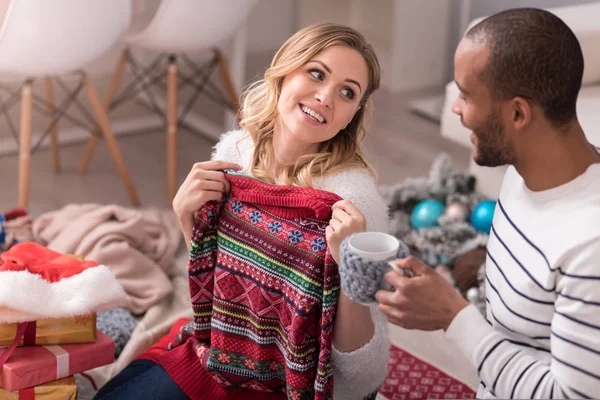 Nice cheerful woman holding a pullover — Stock Photo, Image