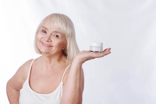 Mulher segurando uma garrafa de creme de umidade — Fotografia de Stock