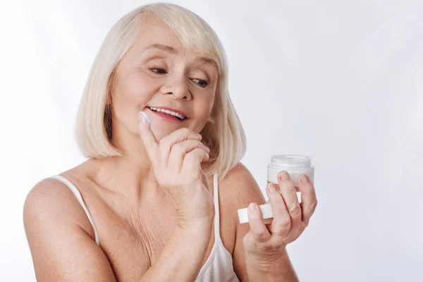 Mujer poniendo crema anti edad — Foto de Stock