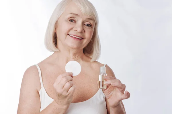 老年妇女使用皮肤的保湿乳液 — 图库照片