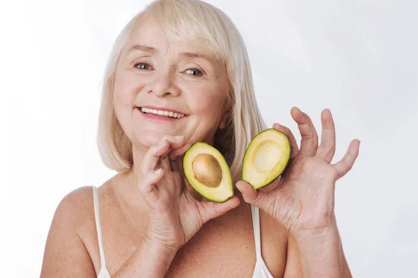 Mujer que le muestra mitades de aguacate — Foto de Stock