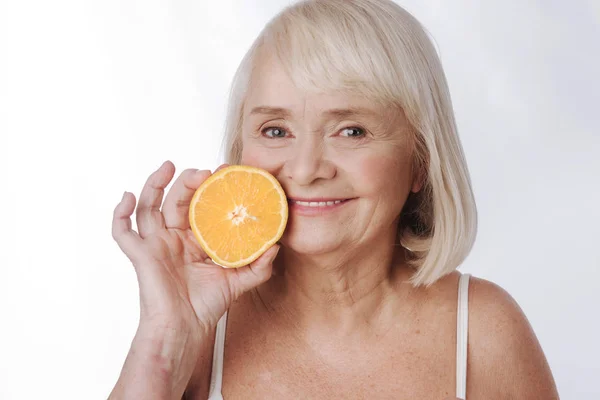 Mujer sosteniendo una mitad naranja — Foto de Stock