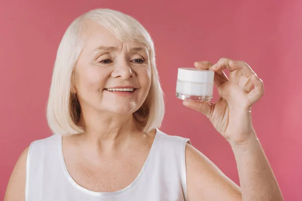 Woman looking at the skin lifting cream — Stock Photo, Image